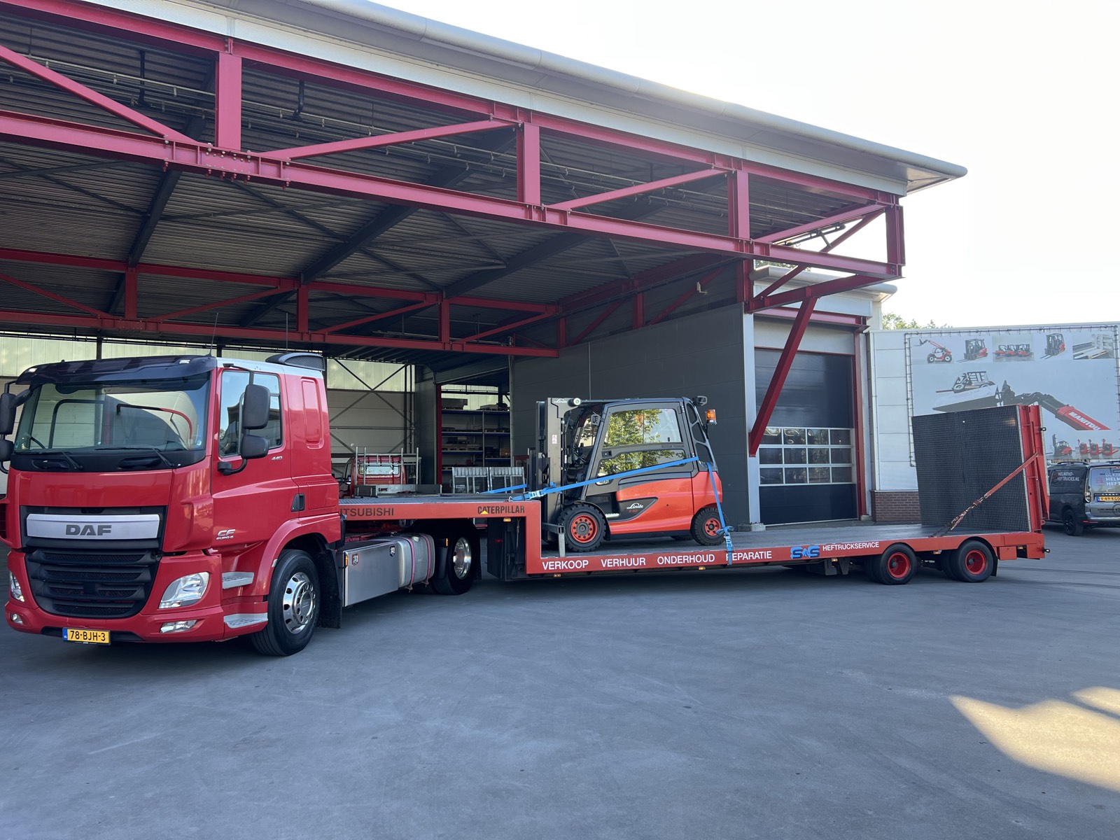 De dieplader van S&S Heftruckservice met een Linde-heftruck vastgesjord op de oprijplaat, voor de werkplaats