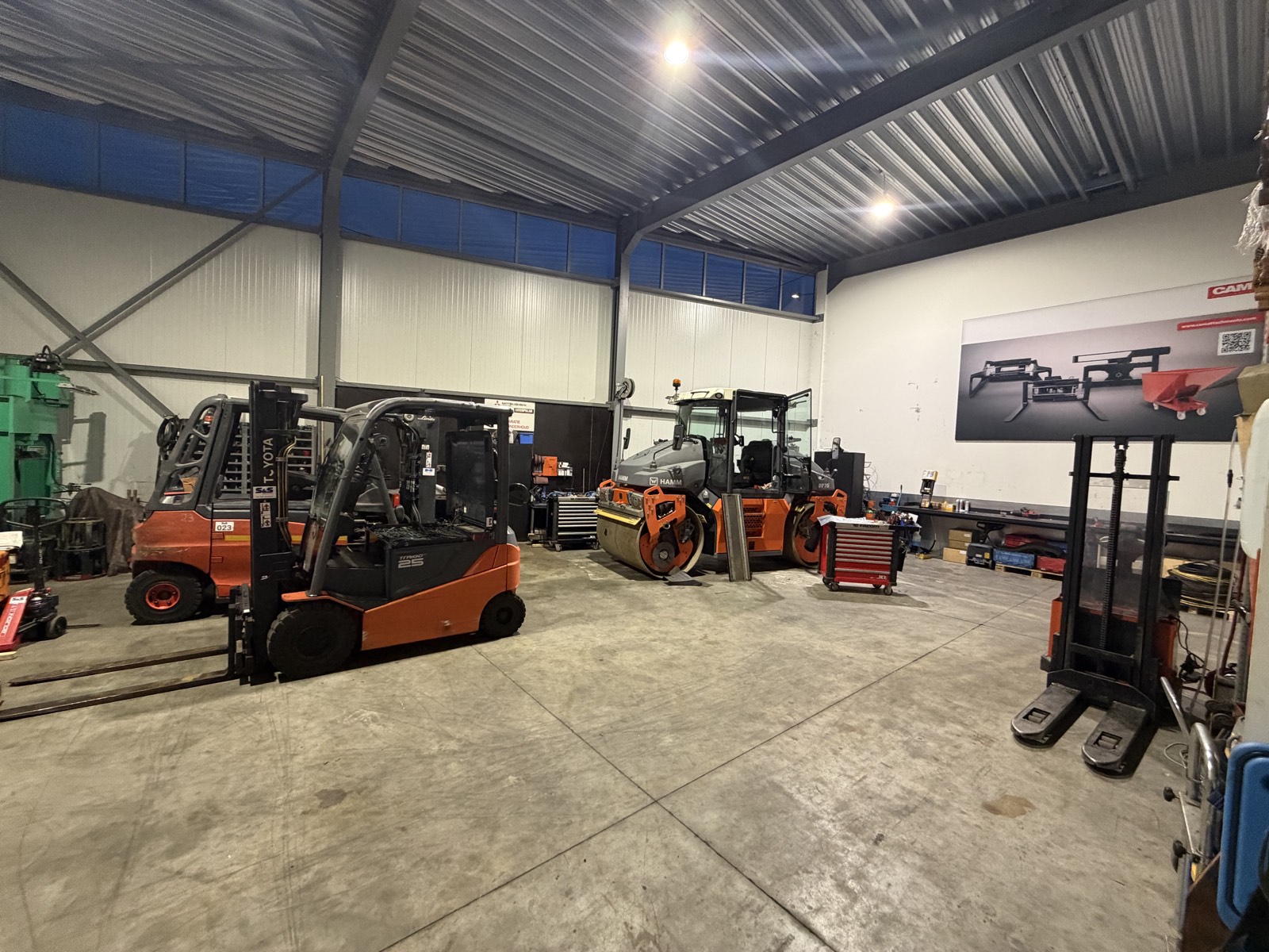 De werkplaats van S&S Heftruckservice in Maastricht, met een heftruck en een wals binnen op de vloer