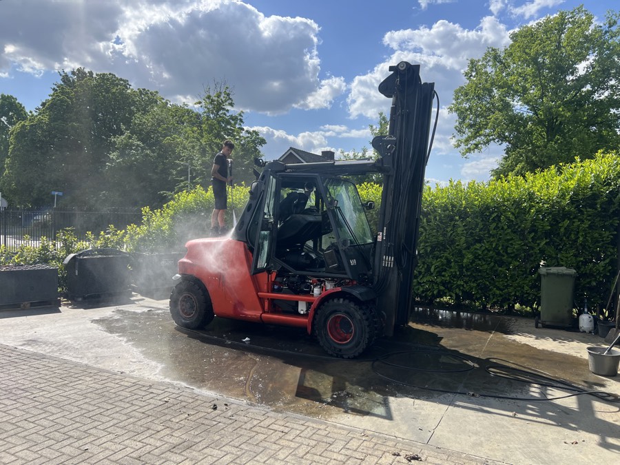 Een Linde-heftruck wordt buiten schoongespoten voordat hij de werkplaats in gaat